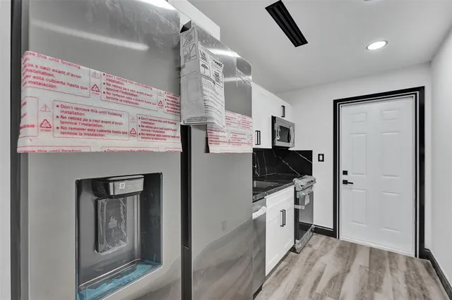 a kitchen with stainless steel appliances granite countertop a stove and a refrigerator