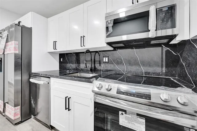 a stove top oven sitting inside of a kitchen