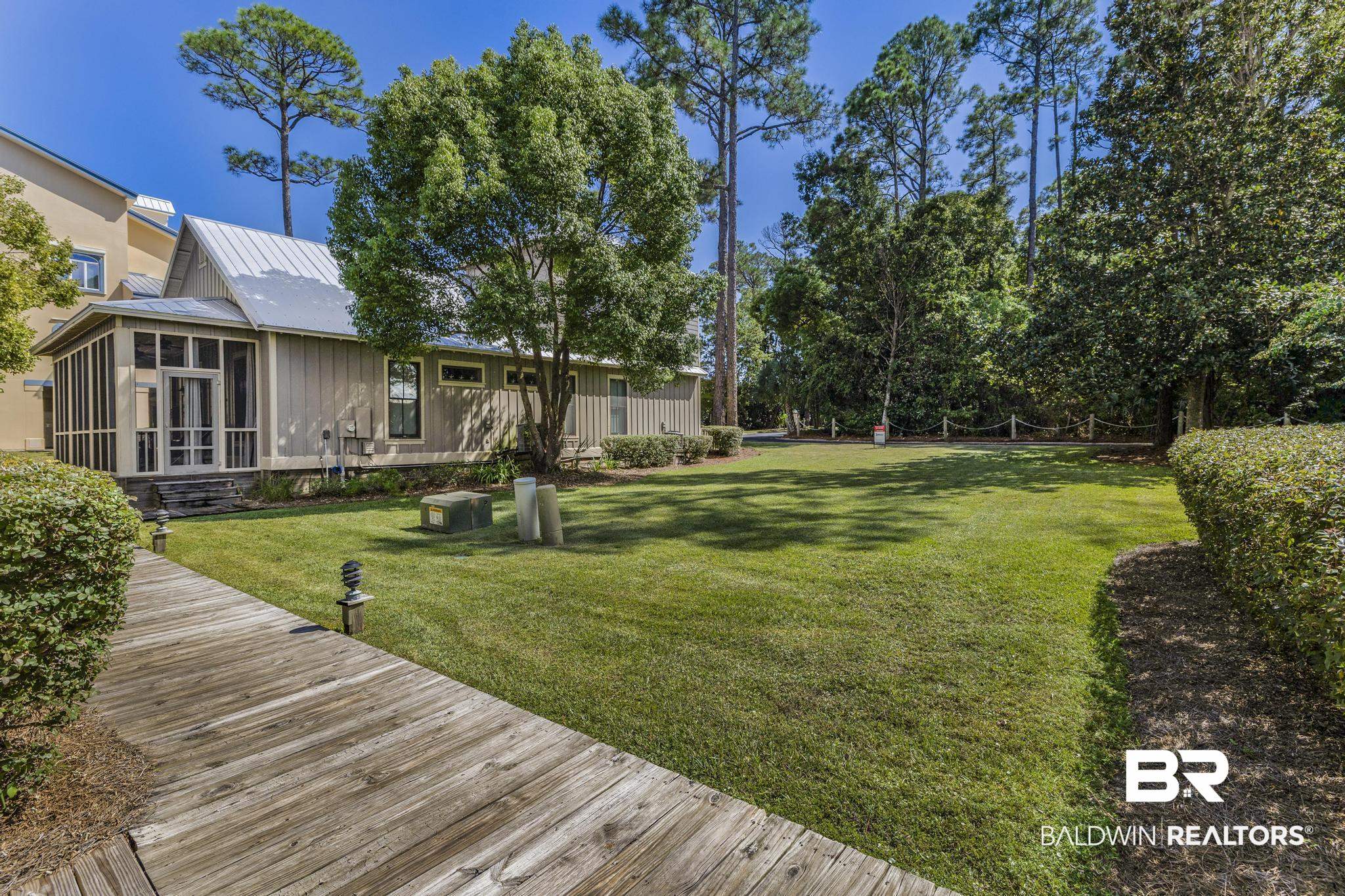 25773 Canal Road Orange Beach, AL 36561 - Photo 3 of 32 View of green lawn featuring a sunroom