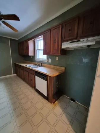 a kitchen with kitchen island granite countertop a sink a counter top space and cabinets