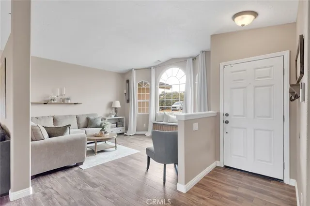 a living room with furniture flat screen tv and a large window