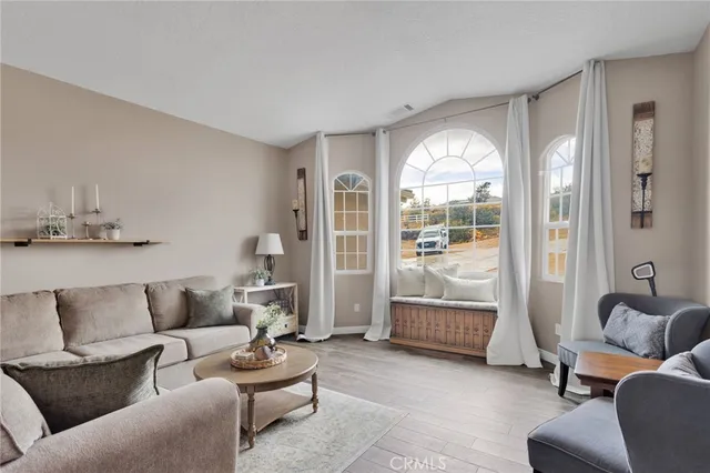 a living room with furniture a chandelier and a flat screen tv