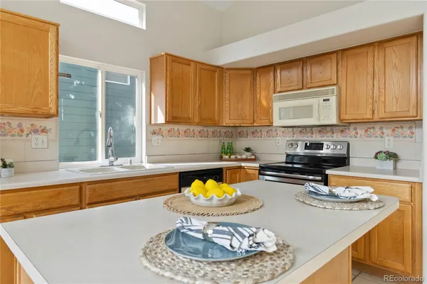 a kitchen with a sink a stove and a wooden cabinets