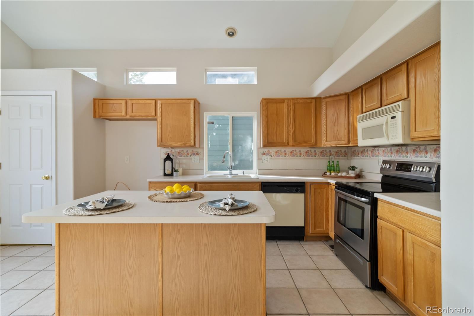 5124 Enid Way Denver, CO 80239 - Photo 17 of 47 a kitchen with stainless steel appliances granite countertop a stove a sink dishwasher and a refrigerator