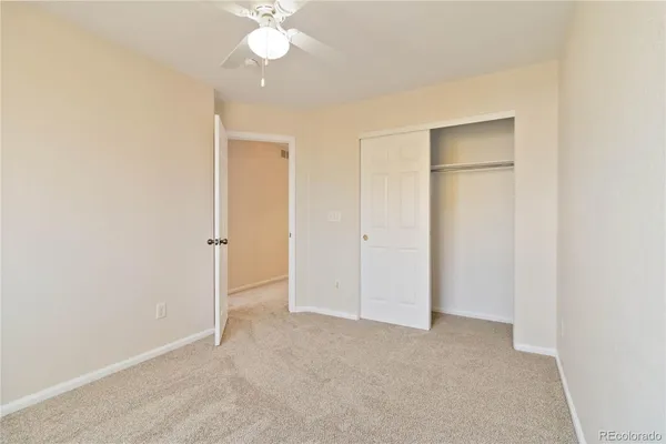 an empty room with a window and a ceiling fan