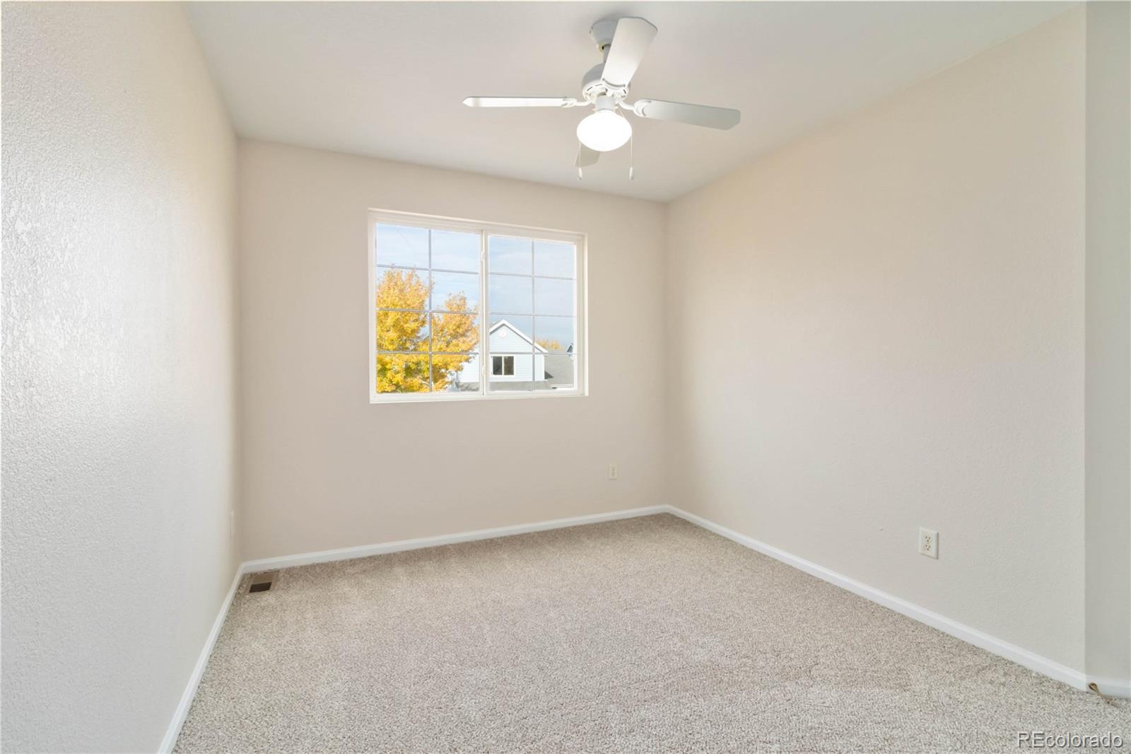 5124 Enid Way Denver, CO 80239 - Photo 34 of 47 an empty room with a window and a ceiling fan