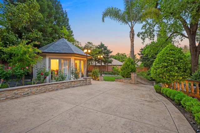 a kitchen with stainless steel appliances kitchen island granite countertop a refrigerator a stove top oven and a dining table with wooden floor