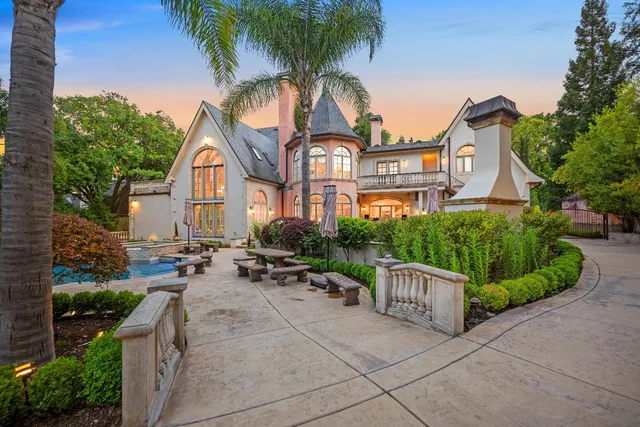 a view of a swimming pool with a patio and fire pit