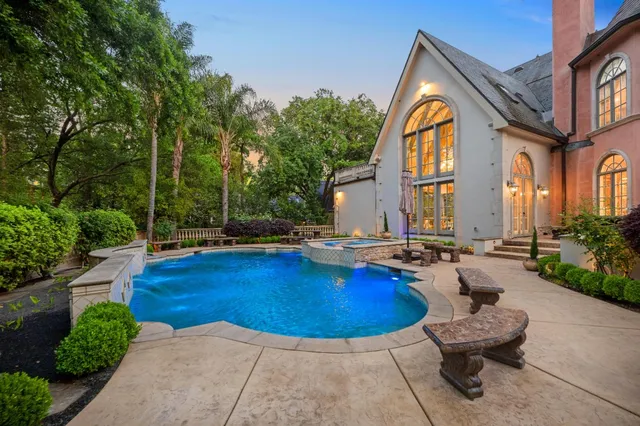 a view of swimming pool with outdoor seating and house in the background