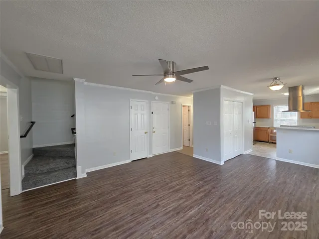 a view of a big room with wooden floor and a kitchen