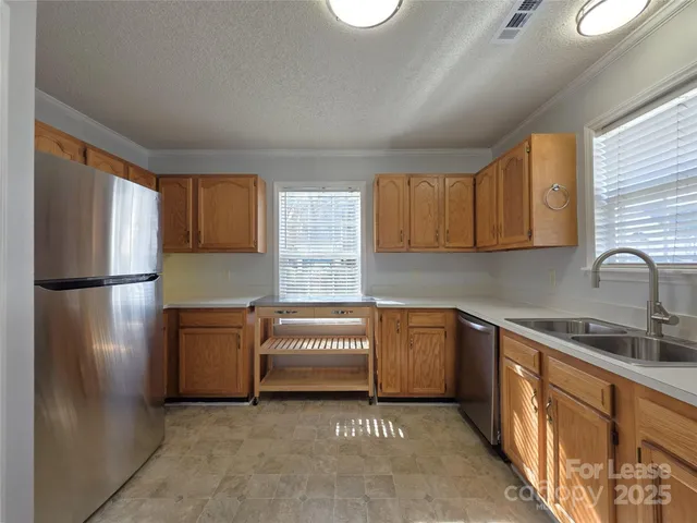 a kitchen with stainless steel appliances granite countertop a refrigerator sink and stove