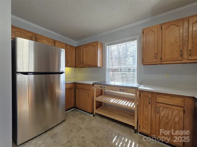 a kitchen with stainless steel appliances granite countertop a refrigerator and a sink