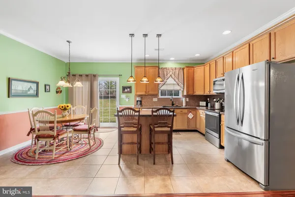 a kitchen with stainless steel appliances granite countertop a refrigerator a stove a sink dishwasher with a dining table and chairs