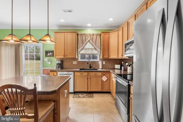 a kitchen with stainless steel appliances granite countertop a stove a sink and a refrigerator