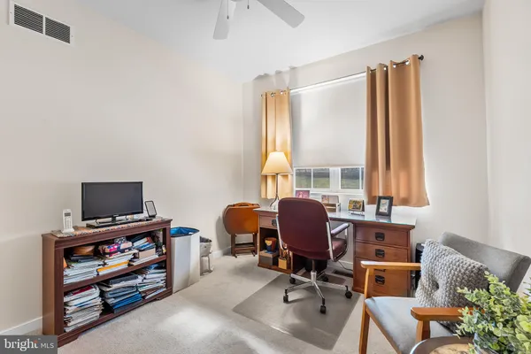 a view of a workspace with furniture and a window