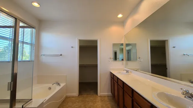 a bathroom with a tub sink shower and mirror