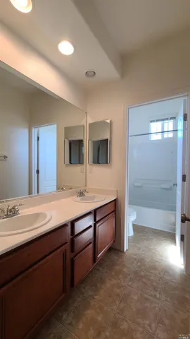 a spacious bathroom with a granite countertop sink mirror and bathtub