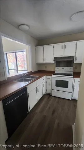 a kitchen with granite countertop a stove a sink and a microwave