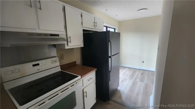 a kitchen with a refrigerator stove and cabinets