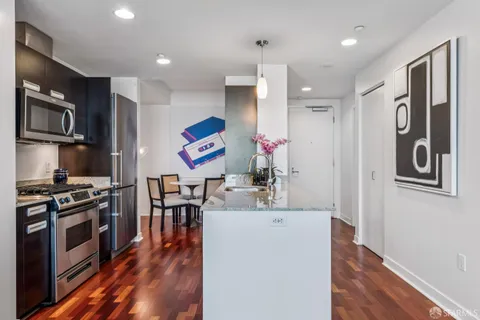 a kitchen with stainless steel appliances kitchen island granite countertop a stove a sink and a microwave