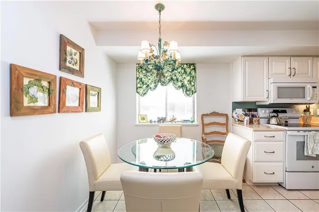 a dining room with chandelier and wooden floor