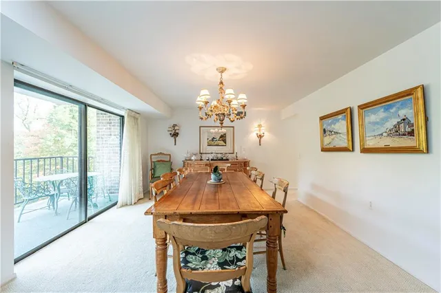 a view of a dining room with furniture a chandelier and wooden floor