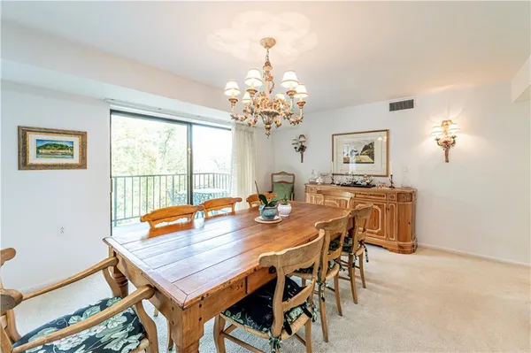 a view of a dining room with furniture and a chandelier