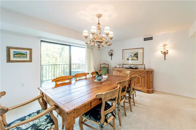 a view of a dining room with furniture and a chandelier