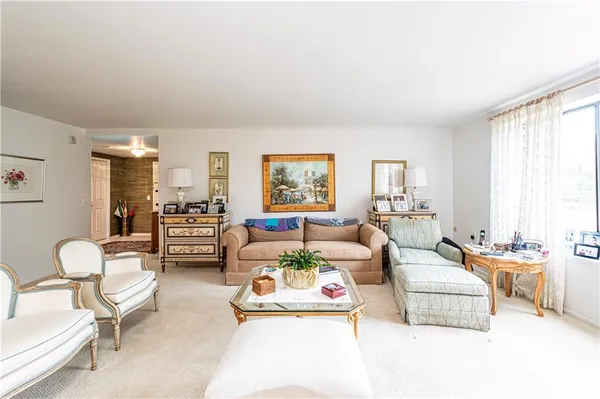 a living room with furniture a flat screen tv and a window