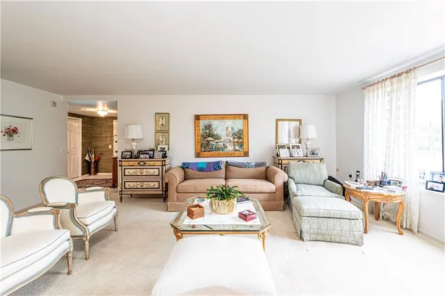 a living room with furniture a flat screen tv and a window