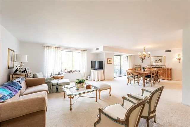 a living room with furniture and a dining table with wooden floor