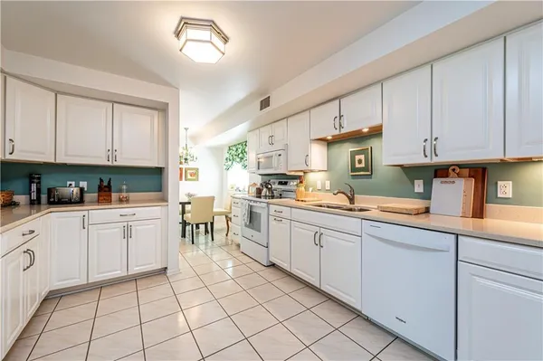 a kitchen with white cabinets appliances and a sink