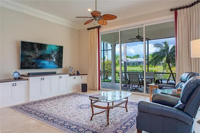 a living room with furniture a flat screen tv and a floor to ceiling window