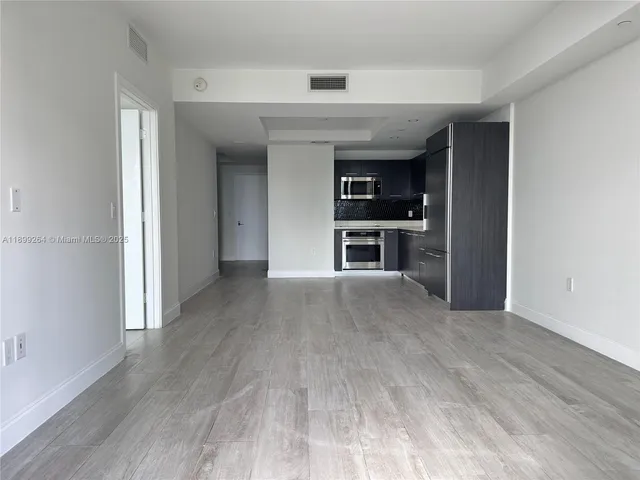 a view of a kitchen with wooden floor and a sink