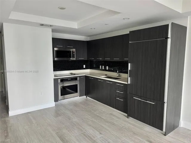 a kitchen with a refrigerator and a stove top oven