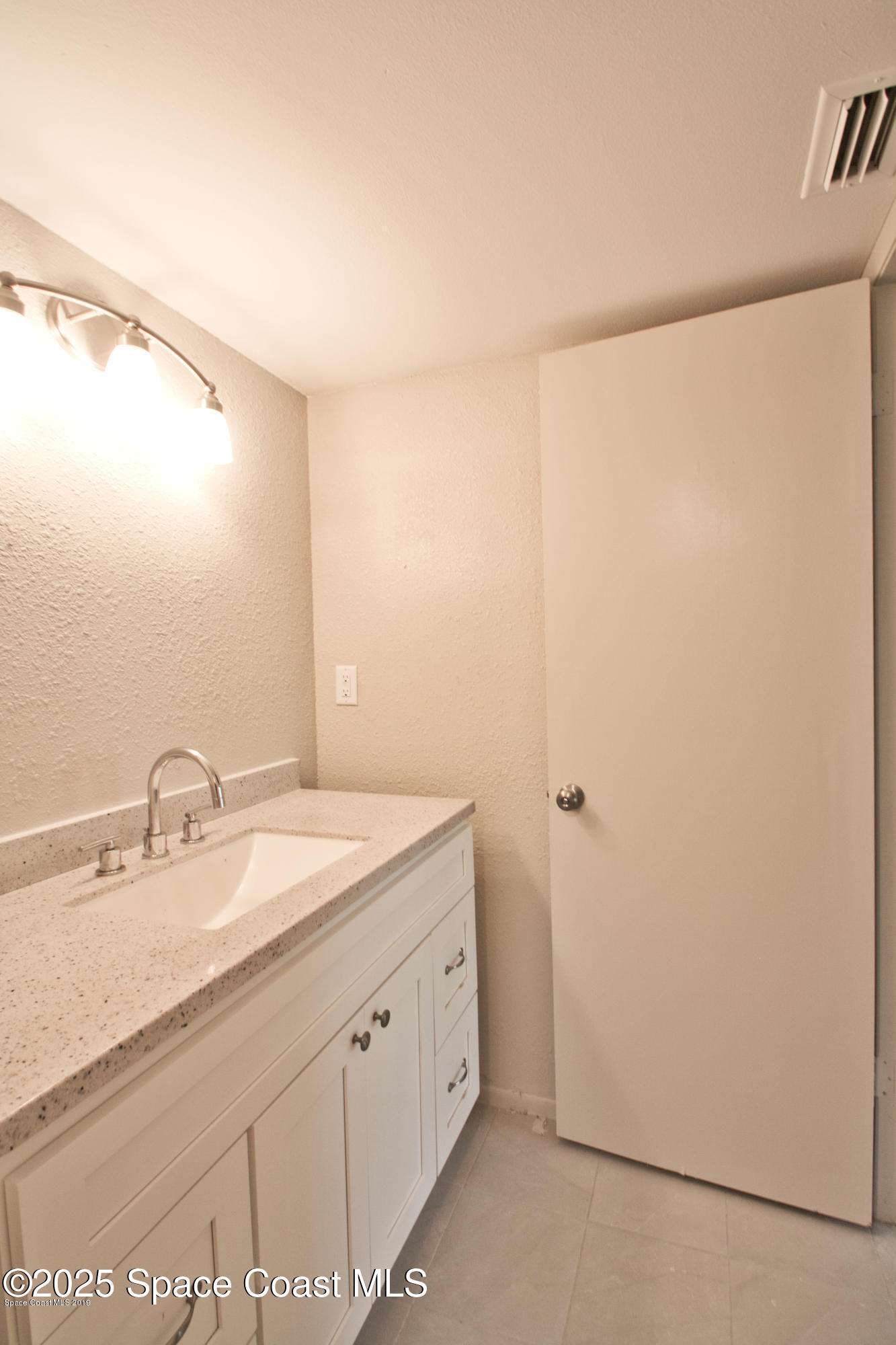 2550 Eagle Drive, Unit 3C Melbourne, FL 32935 - Photo 7 of 14 a bathroom with a double vanity sink and a mirror