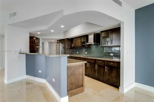 a kitchen with stainless steel appliances granite countertop a refrigerator and a stove top oven