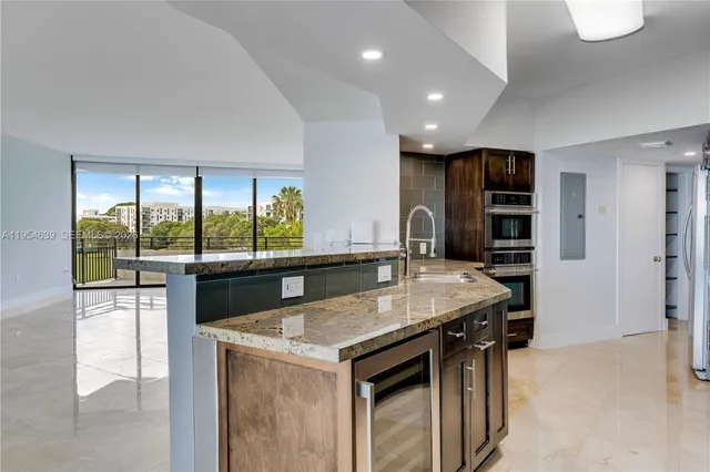 a dining hall with stainless steel appliances granite countertop a stove and a sink