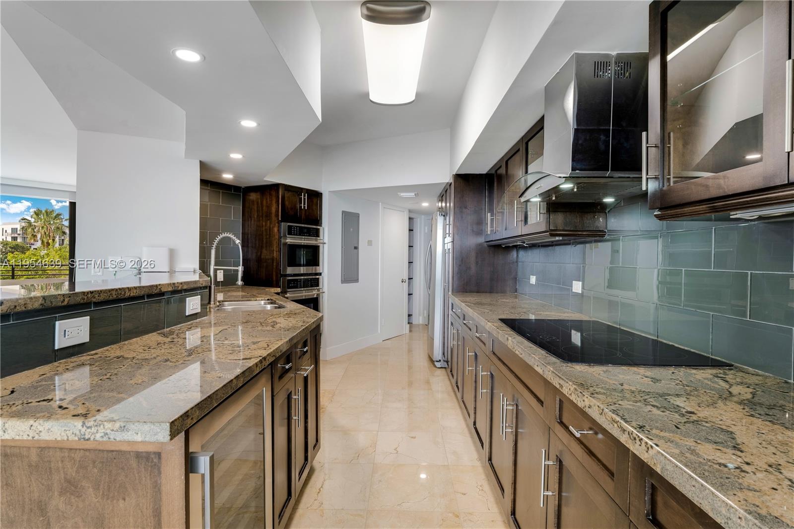 720 Northeast 69th Street, Unit 4S Miami, FL 33138 - Photo 15 of 46 a kitchen with stainless steel appliances granite countertop a sink and a wooden cabinets