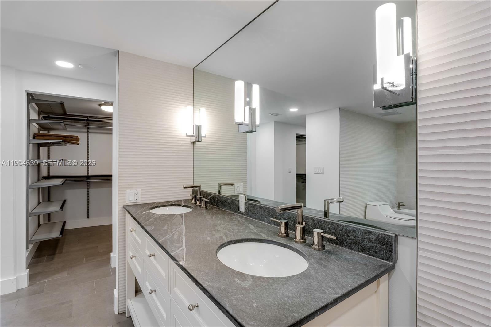 720 Northeast 69th Street, Unit 4S Miami, FL 33138 - Photo 17 of 46 a bathroom with a granite countertop sink and a mirror