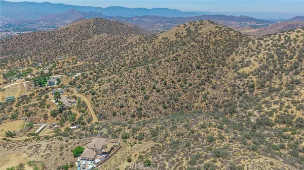 a view of a dry yard with mountains in the background