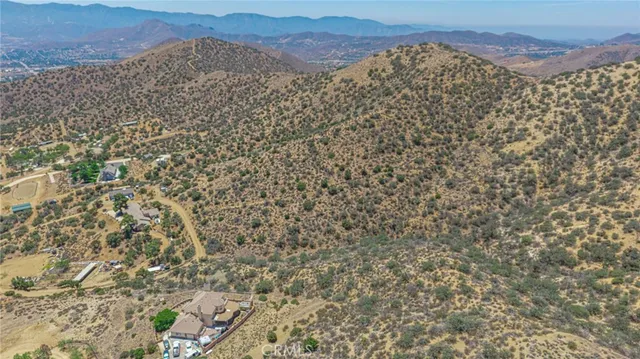 a view of a dry yard with mountains in the background