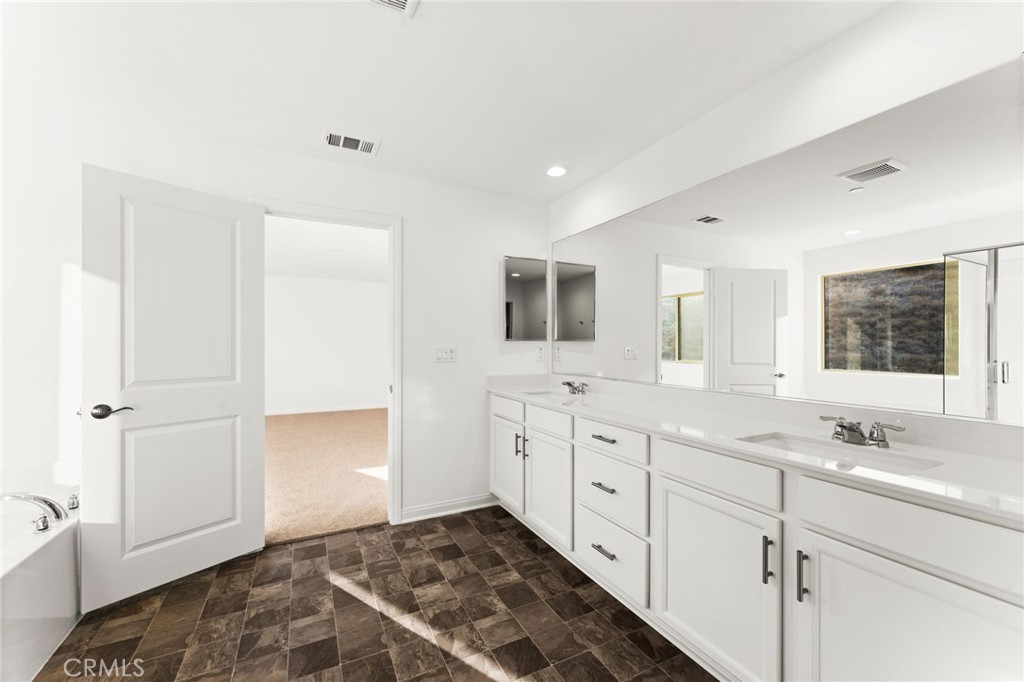 8465 Anthony Street Colton, CA 92324 - Photo 16 of 43 a spacious bathroom with a granite countertop sink mirror and cabinets
