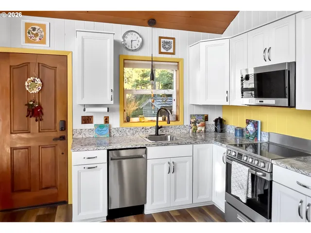 a kitchen with stainless steel appliances granite countertop a stove a sink and a microwave
