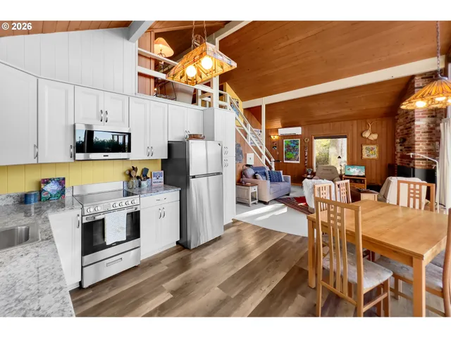 a kitchen with stainless steel appliances granite countertop a refrigerator a microwave a stove and white cabinets