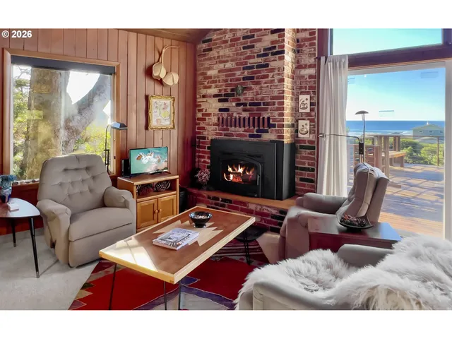 a living room with furniture a fireplace and a large window