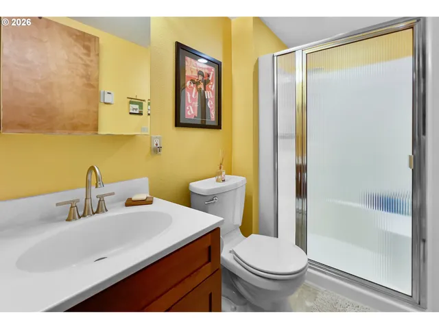 a bathroom with a sink a toilet and shower