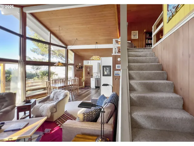 a living room with furniture and a floor to ceiling window
