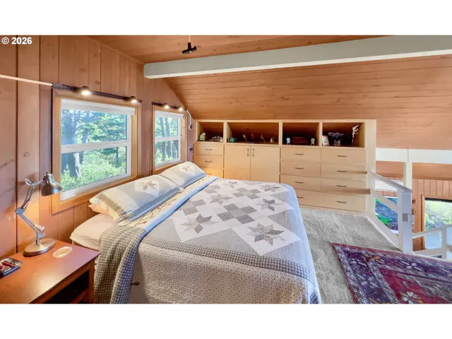 a bedroom with a bed and a flat tv screen on dresser