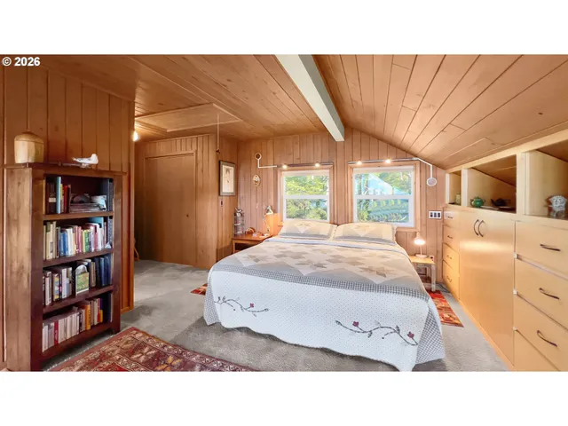 a living room with a bed furniture and a large window